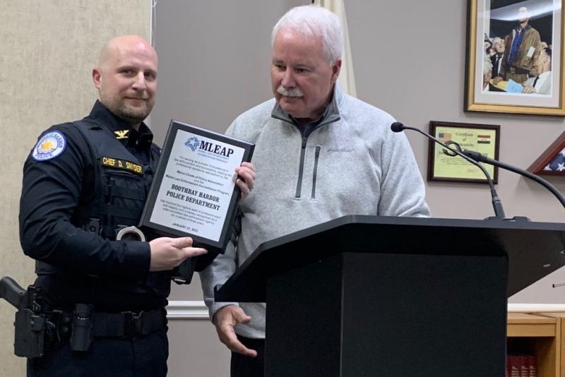 Maine Chiefs of Police Association Executive Director Ed Tolan presents Boothbay Harbor Police Chief Doug Snyder March 13 with a plaque commemorating the department achieving Maine Law Enforcement Accreditation Program certification. BILL PEARSON/Boothbay Register