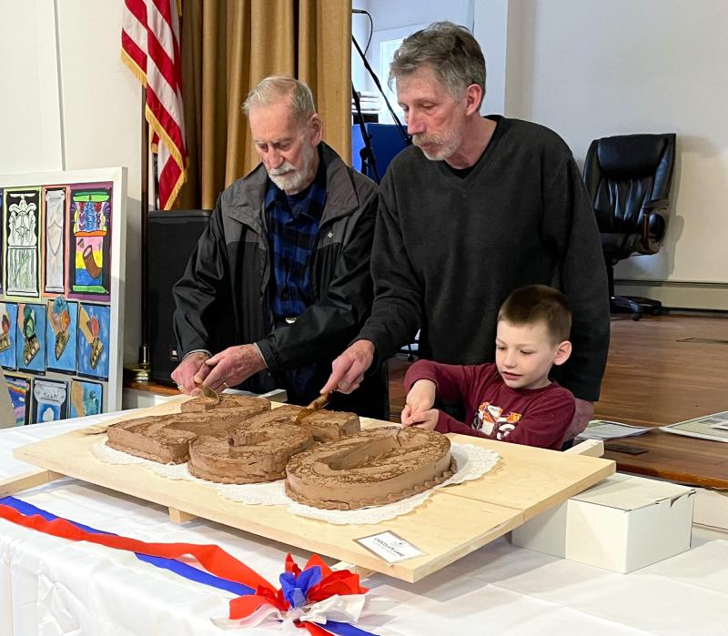The present, past and future generations of Edgecomb cut the ceremonial cake. From left, Willis Clifford, Mike Smith, and Reid Carver. FRITZ FREUDENBERGER/Boothbay Register