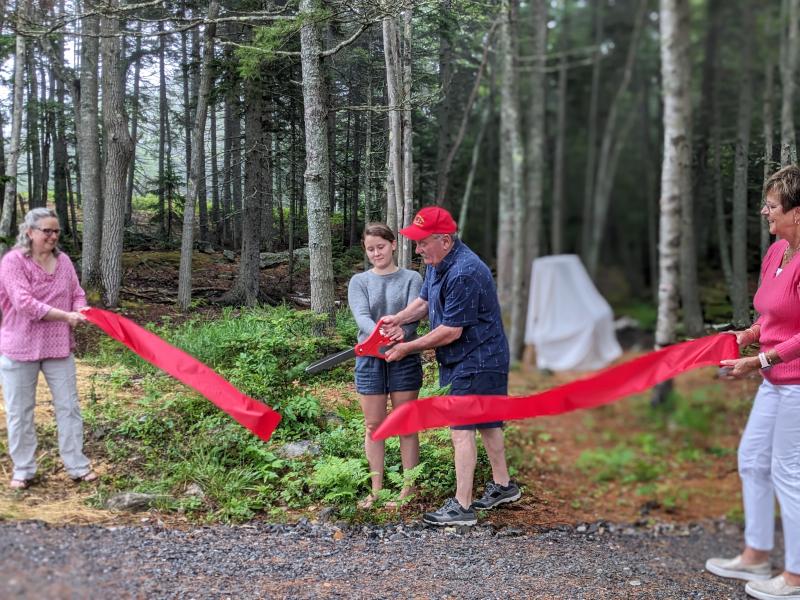 Steve and Madison Gaudette cut the ribbon to open the new Southport Central School woodland playground. CANDI JONETH/Boothbay Register