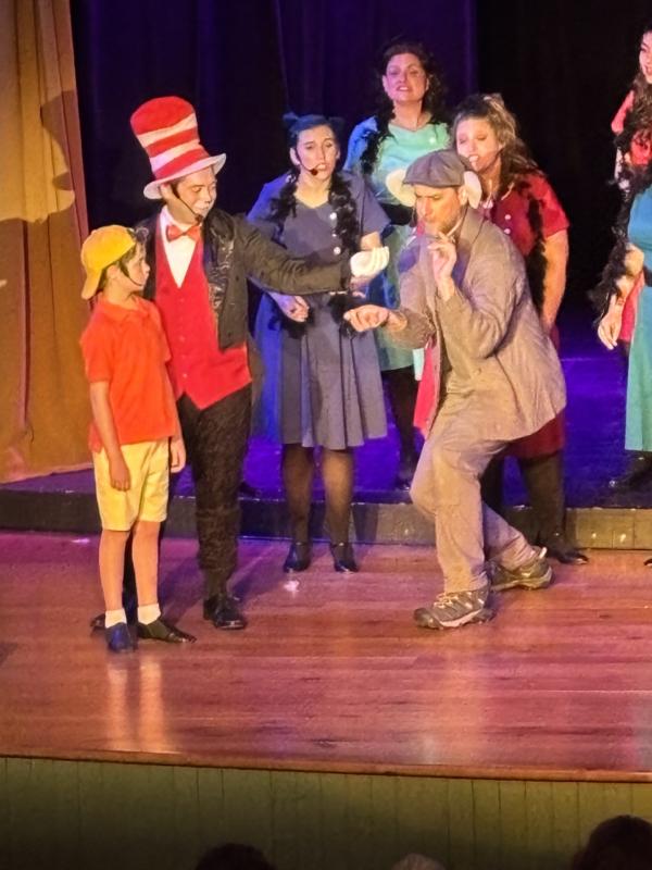 Horton (Soren Barker) gently receives the speckbcontaining Whoville from the Cat in the Hat (Nick Mirabile) with Jojo (Gannon Inman) watching. Grinch (Roosevelt Bishop) antics.
LISA KRISTOFF/Boothbay Register Horton (Soren Barker) gently receives the spec containing Whoville from the Cat in the Hat (Nick Mirabile) with Jojo (Gannon Inman) watching. Grinch (Roosevelt Bishop) antics. LISA KRISTOFF/Boothbay Register