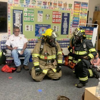 Lt. Chantelle Arsenault and Tyler Lowery show students what a fully dressed firefighter looks like Oct. 11 during a fire safety demonstration at BRES. BILL PEARSON/Boothbay Register