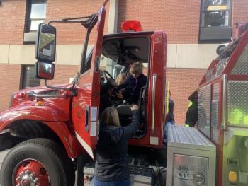 A pre-kindergartener exits a fire truck’s cab after a brief visit inside. BILL PEARSON/Boothbay Register