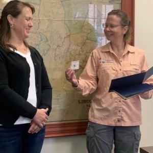 Emergency 911 dispatcher Anita Sprague, left, receives a “Stork pin” Aug. 16 from Communications Center Executive Director Tara Doe during the county commissioners’ meeting. In a June phone call, Sprague assisted a woman through childbirth. BILL PEARSON/Boothbay Register