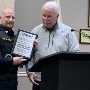 Maine Chiefs of Police Association Executive Director Ed Tolan presents Boothbay Harbor Police Chief Doug Snyder March 13 with a plaque commemorating the department achieving Maine Law Enforcement Accreditation Program certification. BILL PEARSON/Boothbay Register